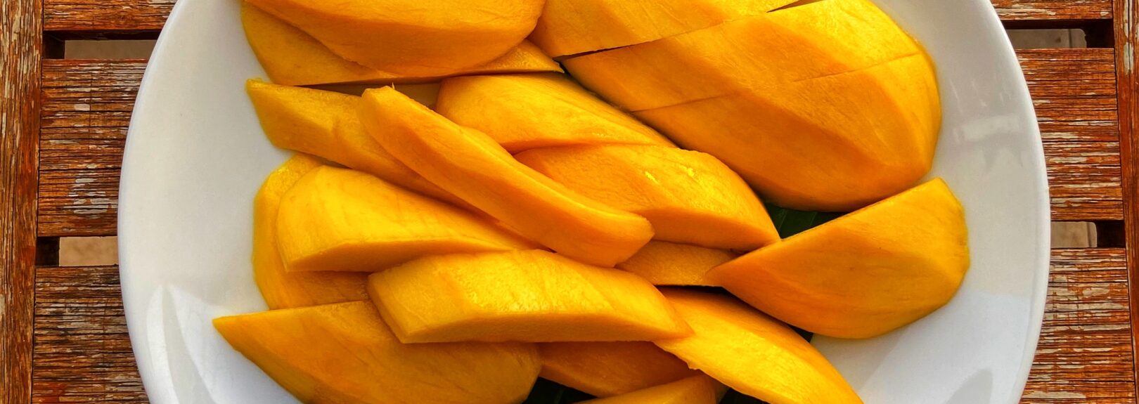 ovocie mango, mango recepty. Mango nakrájané na väčšie kusy na bielom tanieri